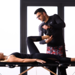 Radu Conea testează musculatura șoldului unei paciente întinse pe masa de terapie